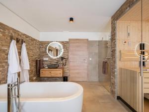 a bathroom with a large tub and a shower at Edelweiss Lodge in Donnersbachwald +53 photos