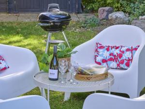 a grill on a table with glasses and a bottle of wine at Sunseeker in Goedereede