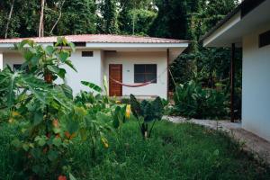 a house with a red hose in a garden at Taki Tambo Lodge in Tarapoto