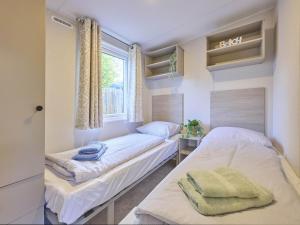 two beds in a room with a window at Sunseeker in Goedereede