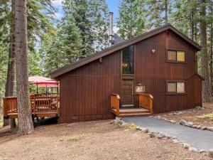 a wooden cabin in the woods with a tree at 1st Cabin in Homewood