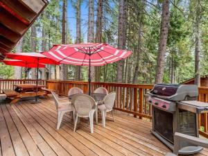 a deck with a table and chairs and a grill at 1st Cabin in Homewood