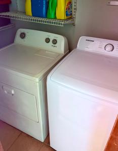 a white washer and dryer sitting next to each other at Escape Caribeño in Levittown