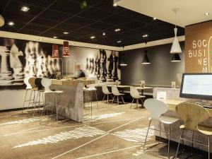 a restaurant with a bar with stools and a tv at ibis Edinburgh Centre Royal Mile in Edinburgh