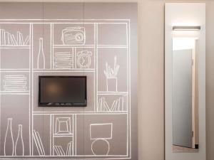 a wall with a tv and drawings on it at ibis Edinburgh Centre Royal Mile in Edinburgh