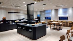 a restaurant with a counter and tables and chairs at Smile Hotel Otsu Seta in Otsu