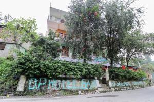 a building with trees on the side of a street at Hotel O Dp Bar in Rāmpur