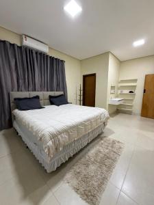 a bedroom with a large bed and a rug at casa conforto e piscina in Sinop +19 photos