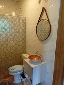 a bathroom with a sink and a toilet and a mirror at Sol & mar Hospedagem - Boqueirão Sul Via Balsa Cananéia in Ilha Comprida +20 photos