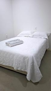 a white bed with white sheets and towels on it at Recanto de Boipeba in Ilha de Boipeba