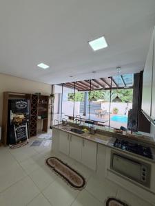 a kitchen with a view of a pool through the windows at casa conforto e piscina in Sinop