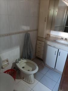 a small bathroom with a toilet and a sink at Bodegon in Encarnación