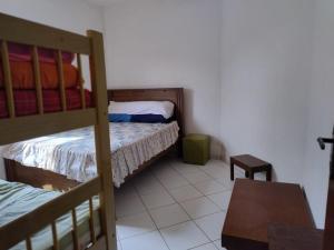 a small room with two bunk beds and a table at Casa Garcia in Ilha Comprida