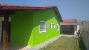 a green building with a window on the side of it at Casa Garcia in Ilha Comprida +11 photos