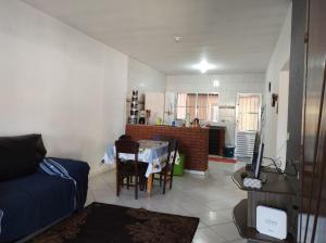 a living room with a table and a kitchen at Casa Garcia in Ilha Comprida