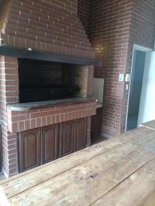 an outdoor brick fireplace with a wooden deck at Bodegon in Encarnación
