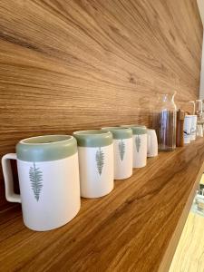 Eine Reihe Kaffeetassen steht auf einer Holztheke. in der Unterkunft Vista Izera in Świeradów-Zdrój