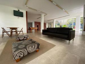 a living room with a black couch and a table at Lisbon Lux T1 Pool Gym Tennis AC - Pouso dos Anjos Apartment in Lisbon