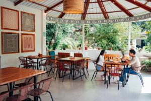 a man and woman sitting at tables in a restaurant at Taki Tambo Lodge in Tarapoto