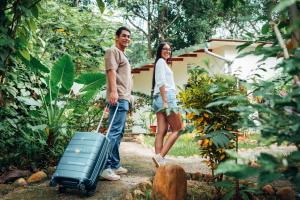 a man and a woman walking with a suitcase at Taki Tambo Lodge in Tarapoto