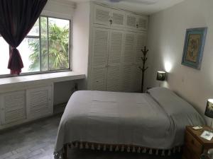 a bedroom with a large bed and a window at casa HIKURI in Cancún