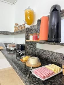 a kitchen counter with meat and cheese on a plate at Pousada do pc in Bom Jesus do Itabapoana