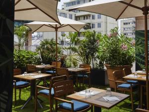 a restaurant with tables and chairs and umbrellas at ibis Styles Toulon Centre Port in Toulon