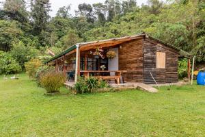 a small wooden cabin in a field of grass at La cabaña del Búho in Cali