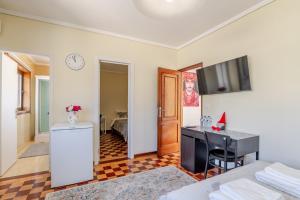 a room with a bed and a desk and a television at Maia Oporto Suites in Maia