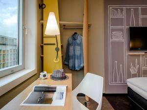 a living room with a couch and a table and a chair at Ibis Münster City in Münster
