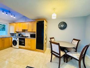 a kitchen with a table and chairs and a black refrigerator at Duchess Victoria Haven in Drogheda
