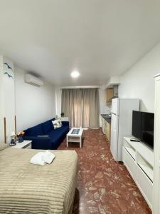 a living room with a bed and a blue couch at A la Orilla del Mar in Matalascañas