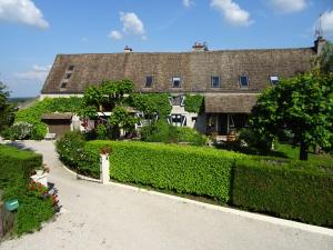 a house with a hedge in front of a building at Le Jardin Suspendu in Chivres