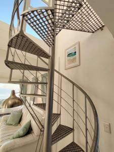a spiral staircase in a living room with a couch at Atlantic Canvas - Mountain and Sea in Cape Town