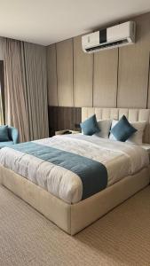 ein Schlafzimmer mit einem großen Bett und blauen Kissen in der Unterkunft Highest End Hotel in Al-'Ula