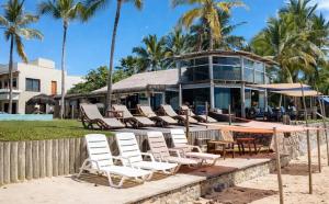 a group of chairs and tables in front of a building at Arraial Praia Hotel Pousada in Arraial d'Ajuda
