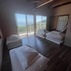 a room with four beds and a large window at salvia blue in Miyazaki