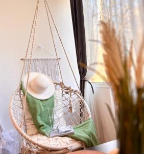 a hanging chair with a hat and a glass of wine at Sleep & Go Floreasca Green in Bucharest +42 photos