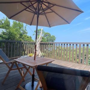 a table with an umbrella and a chair on a deck at salvia blue in Miyazaki