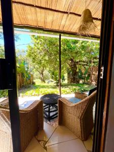 a screened in porch with a view of a patio at Jambalau House in Lopes +4 photos