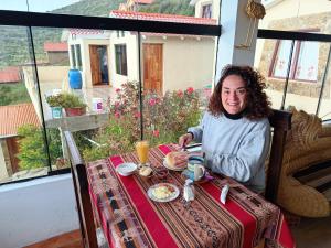 a woman sitting at a table with a plate of food at Palacio del Inca Lodge in Comunidad Yumani +30 photos