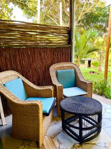 two wicker chairs and a table on a patio at Jambalau House in Lopes