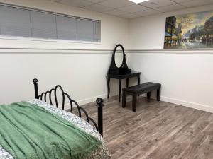 a room with a bed and a chair and a table at Charming Central Abbotsford Retreat, Cozy Suite in Abbotsford