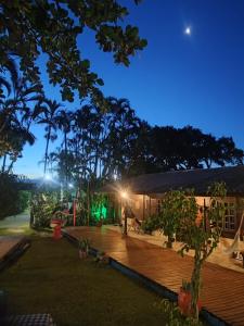 a house with a wooden deck at night at Pousada Lua Cheia in Ilha do Mel
