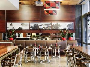 a restaurant with wooden walls and tables and chairs at ibis Wellington in Wellington