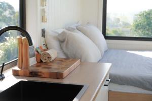 Eine Küchentheke mit einem Schachbrett auf einem Tisch neben einem Bett in der Unterkunft Tiny Heidi in Imbil