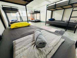 a bedroom with two bunk beds in a room at Hee Pee hostel Buriram in Sathani Buriram