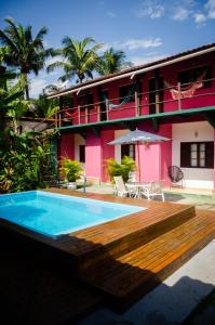 a house with a swimming pool and a wooden deck at Pousada Pitaya Maresias in Maresias
