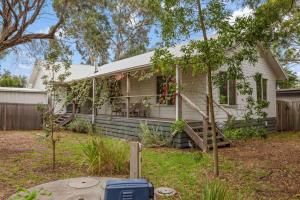 a white house with a porch and a yard at Beach House Silverleaves in Cowes