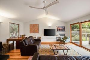 a living room with a couch and a tv at Beach House Silverleaves in Cowes